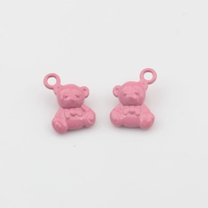 Detailopname van twee roze emaille beertjes hangers met lussen voor DIY-sieraden maken