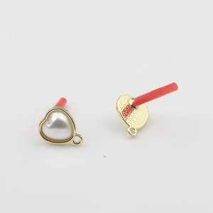 Macro detail of heart pearl earring stud with gold metal base and bottom hanging loop