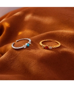 Detailaufnahme von Boho-Ringen mit Türkis und Achat auf dunklem Samthintergrund