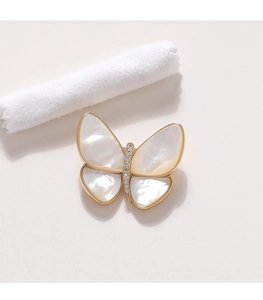 Detail einer eleganten Schmetterlingsbrosche mit Perlmuttflügeln und Goldakzenten