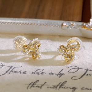 Eleganti clip per orecchie geometriche dorate con perle e cristalli su sfondo vintage