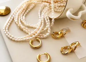 Detailed close-up of multi-layer freshwater pearl necklace and gold alloy earrings