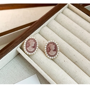 Detailed close-up of French vintage cameo earrings with pink relief and pearl trim