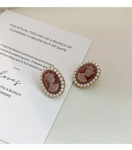 Detailed close-up of French vintage cameo earrings with pink lady relief and mini pearls