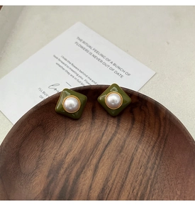 Détail de boucles d'oreilles carrées en émail vert foncé et perles sur bois