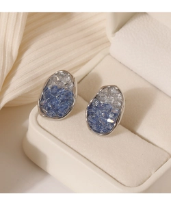 Detalle de pendientes ovalados de plata con cristales azules degradados en estuche