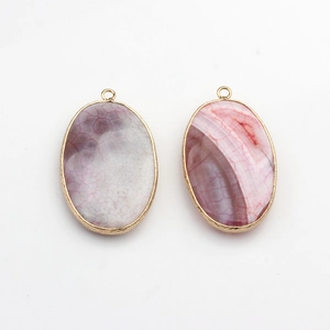 Macro shot of oval agate pendants with gold metal frames and detailed natural stone textures