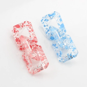 Macro shot of rectangular resin chain links in red and blue spotted translucent patterns