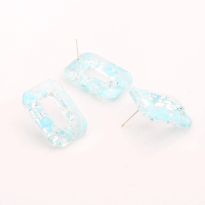 Close-up of geometric resin rectangle earrings with blue flake inclusions and silver pins