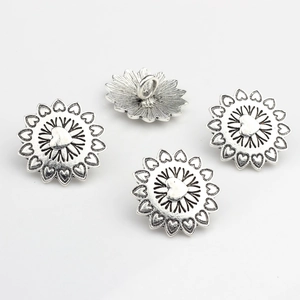 Detailed view of vintage alloy flower buttons with hollow heart petals and silver finish