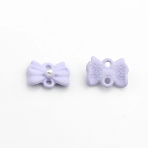 Dettaglio di un ciondolo a fiocco viola chiaro con perla e doppi fori per gioielli fai da te
