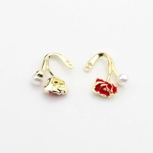 Detail of DIY earring pendants with red enamel rose flowers and white faux pearls in gold
