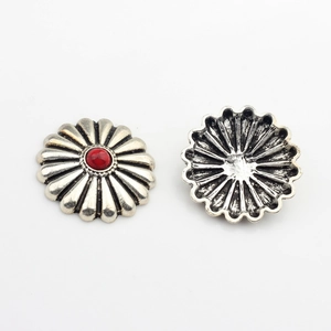 Macro view of vintage daisy resin button with silver finish and red stone inlay detail