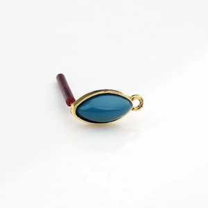 Detailed view of vintage gold marquise resin earring charm with blue stone inlay