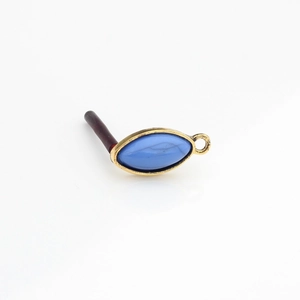 Macro shot of vintage marquise blue resin stone in aged gold alloy earring setting