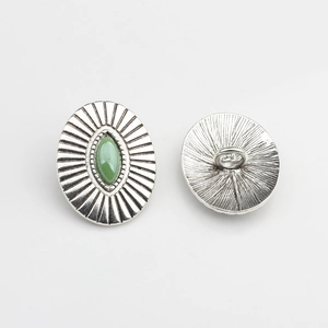 Detail of vintage silver oval alloy buttons with green faux stone and textured finish