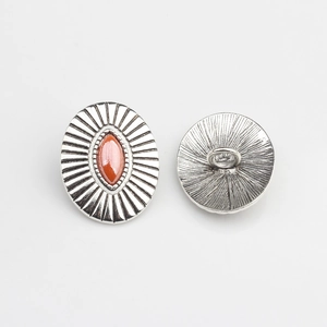 Detailed view of vintage silver alloy shank button with oval red resin stone inlay