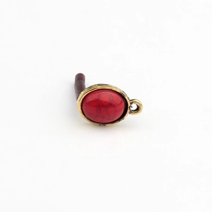 Makrodetail eines Vintage-Bronze-Anhängers mit ovalem, rot strukturiertem Harzstein