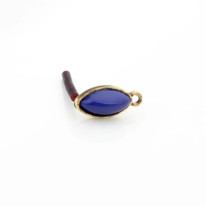 Detail of vintage gold alloy eye-shaped earring component with deep blue resin stone