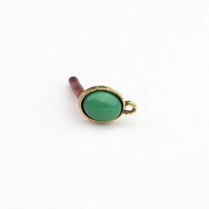 Detail eines ovalen grünen Harz-Cabochons in Bronze-Fassung für DIY-Ohrringherstellung