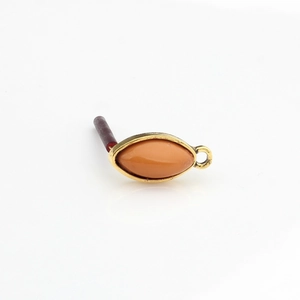 Macro detail of vintage gold horse-eye resin earring connector with amber stone inlay