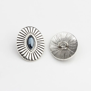 Macro detail of antique silver oval buttons with navette dark stone inlay and ray texture