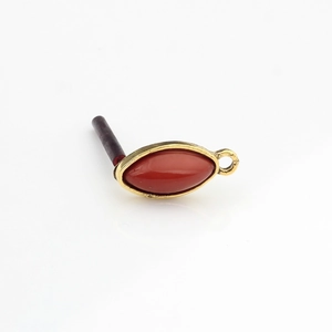 Detail view of retro horse-eye red resin charm with gold metal frame for DIY earring making