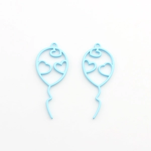 Close-up of light blue hollow balloon charms with heart cutouts for DIY jewelry making