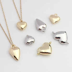Close-up of heart-shaped pendants with Sweetie engraving in gold and silver finish