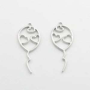 Macro shot of silver hollow balloon charms with heart patterns for DIY jewelry making