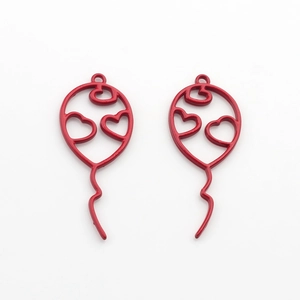 Close-up of red hollow metal balloon charms with heart details for DIY jewelry making