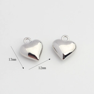 Close-up of polished silver heart pendants showing dimensions of 13mm by 12mm