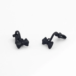 Detail view of matte black bow-shaped earrings with smooth finish and minimalist style