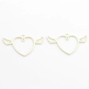 Macro shot of cream-colored winged heart alloy charms for DIY jewelry making