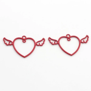 Detailed view of red hollow heart-shaped wing charms for DIY jewelry making
