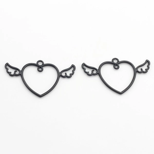 Close-up of two black heart wing charms for DIY jewelry making and necklace crafts
