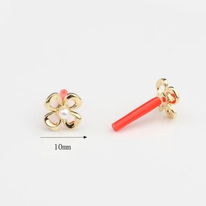 Detail showing 10mm gold flower earrings with white pearl center and red backing