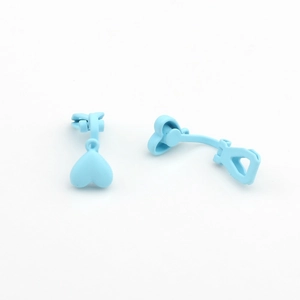 Close-up of matte light blue heart-shaped ear clips with U-shaped non-piercing backs