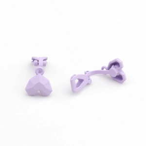 Detail of lavender matte heart-shaped clip-on earrings with faceted surface and clip back
