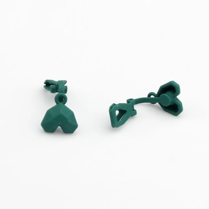Macro view of matte dark green heart-shaped clip-on earring components for DIY jewelry