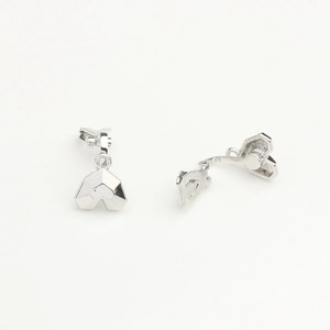 Macro view of geometric faceted heart pendants in polished silver for jewelry DIY