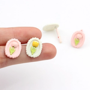 Dettaglio dell'orecchino a bottone con tulipano 3D e rilievo floreale su sfondo bianco