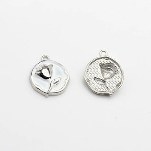 Detail of round rose flower enamel pendants showing front design and textured back