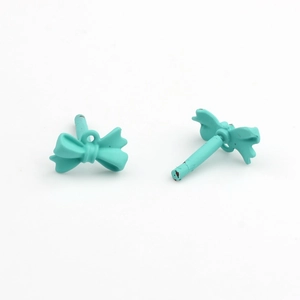 Detailed view of mint green bow stud earrings with matte finish and DIY hanging loops