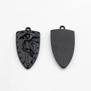 Detailed view of black shield pendant showing winged knight relief and brushed metal texture