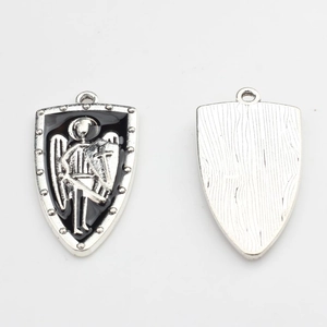 Detail of silver alloy shield charms with black enamel and knight relief for DIY jewelry