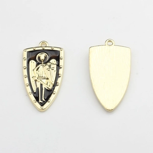 Detail view of gold shield charms with black enamel and warrior relief for DIY jewelry