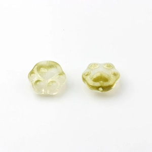 Macro detail of cat paw glass charms with olive green glitter for DIY jewelry making