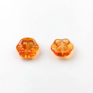Macro detail of amber orange glass cat paw beads with heart pattern for DIY jewelry