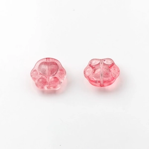 Detail view of pink glittery cat paw glass beads with heart relief for DIY jewelry